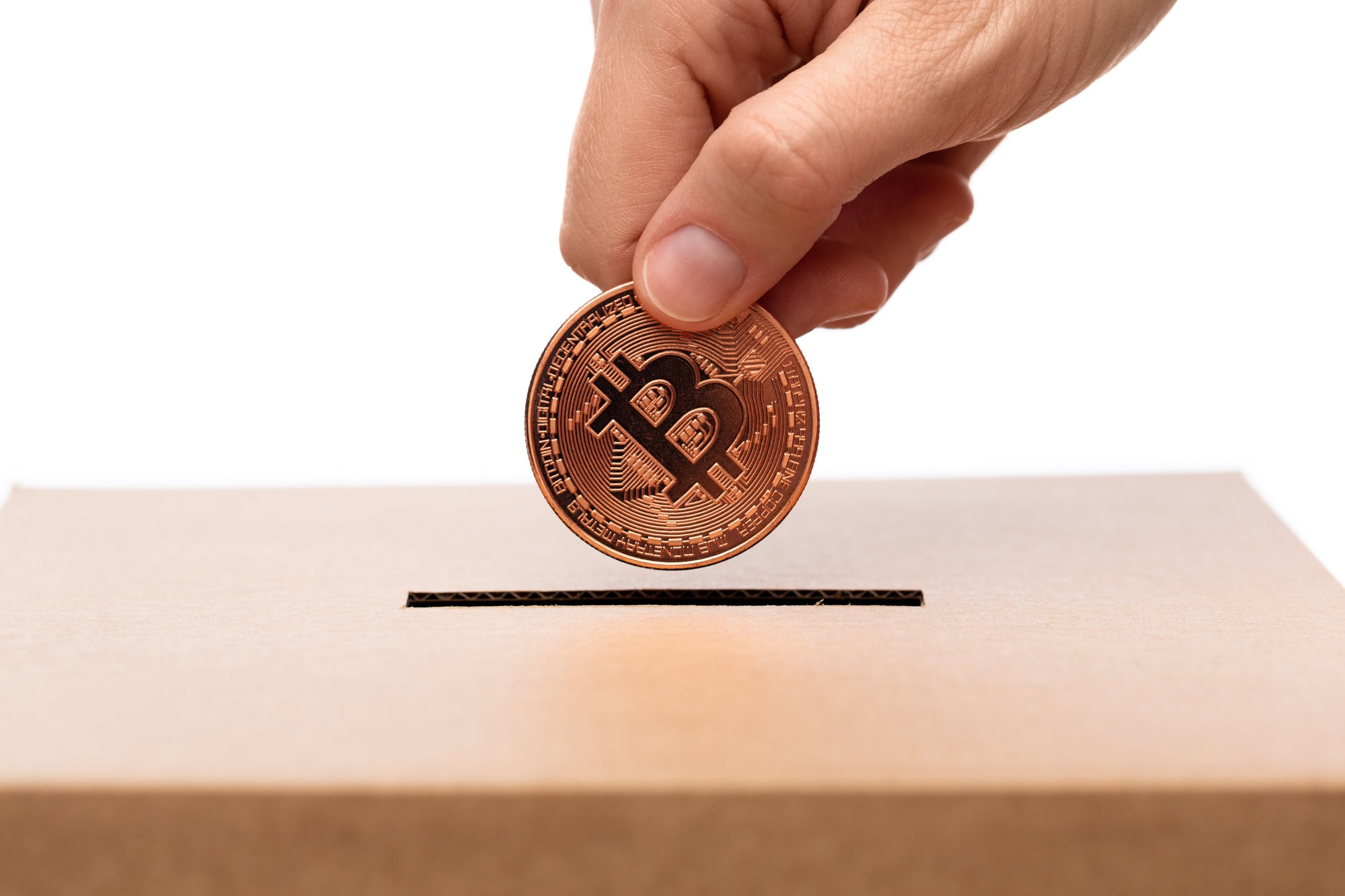 Hand putting Bitcoin into charity donation box