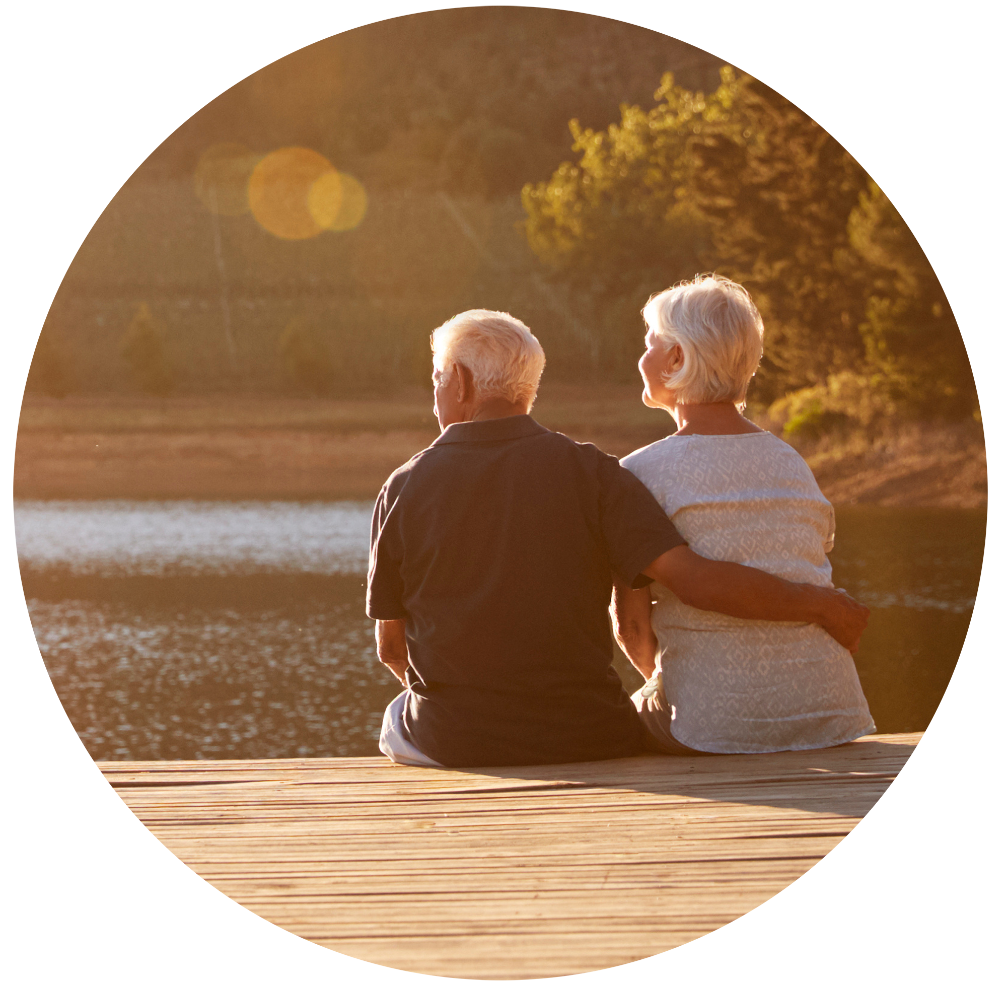 Couple on dock overlooking water at sunset