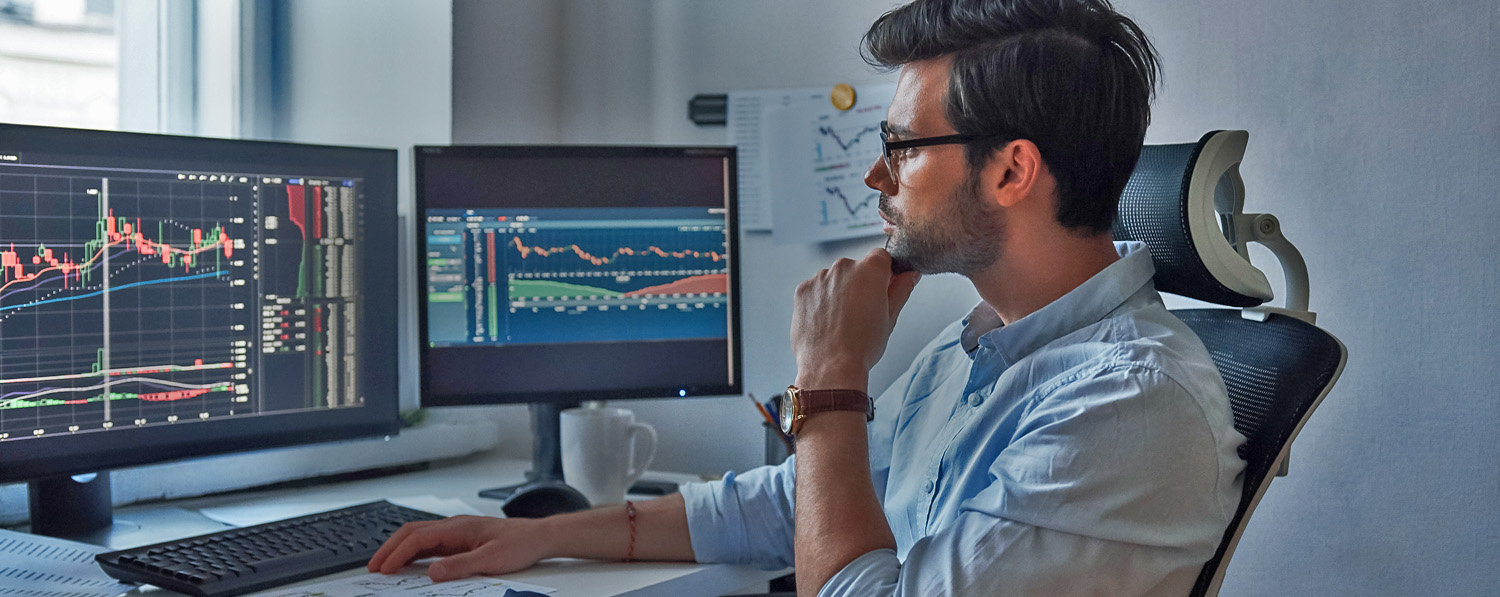 Man looking at computer screen on desk as he donates restricted stock to charity