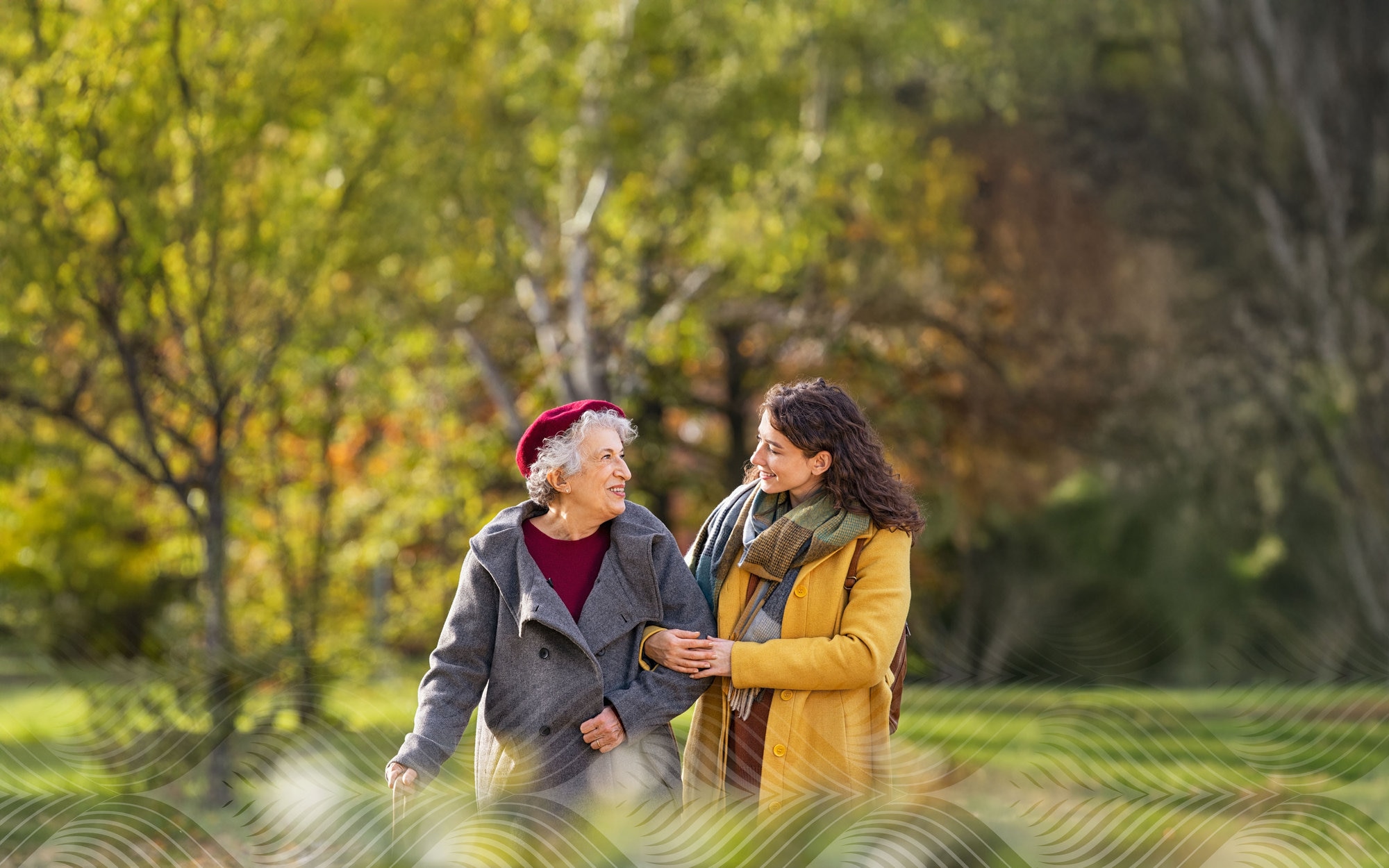 Women walking arm in arm in park during autumn